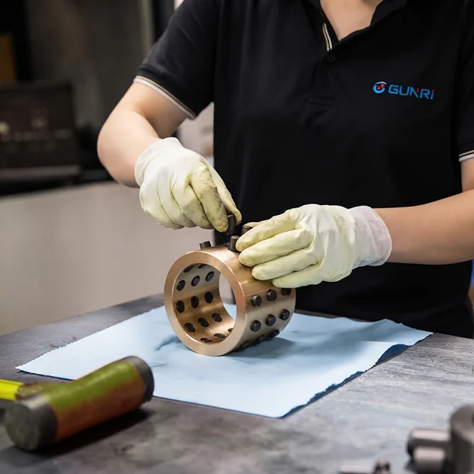 factory worker assembling self-lubricating bronze construction bearing with graphite plugs, precision machined brass bushing in industrial workshop, self-lubricating construction bearings manufacturing process